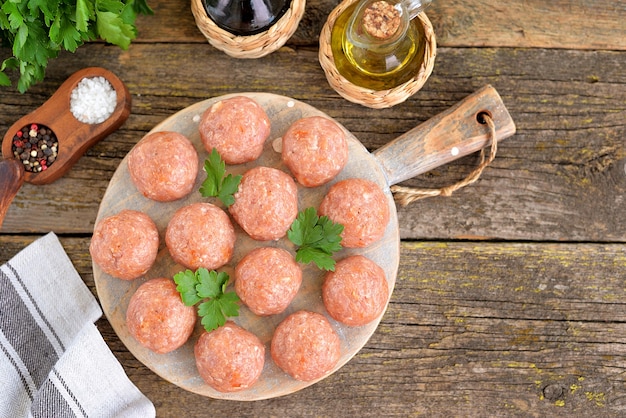 Photo raw meatballs on a wooden board