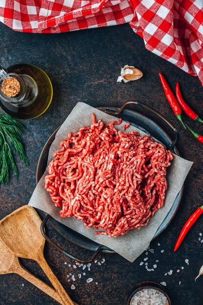 Raw minced beef meat on a tray over black background