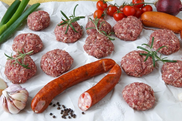 Raw minced hamburger meat and sausage with herb and spice prepared for grilling