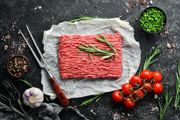 Raw minced meat on a black surface Top view Free space for your text