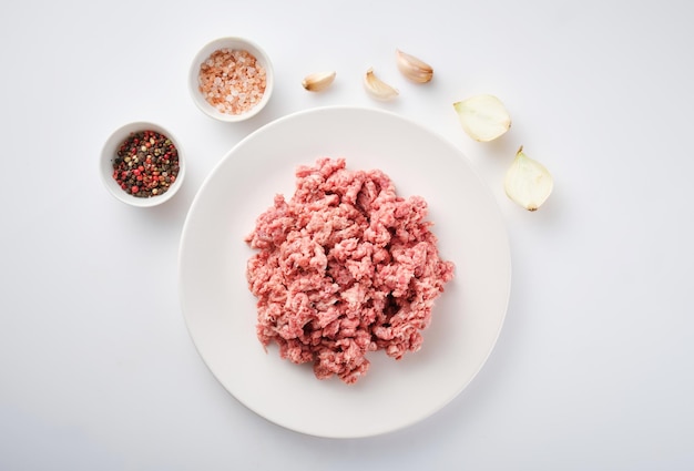 Raw minced meat on the white plate Fresh pork minced meat on white background Raw minced pork