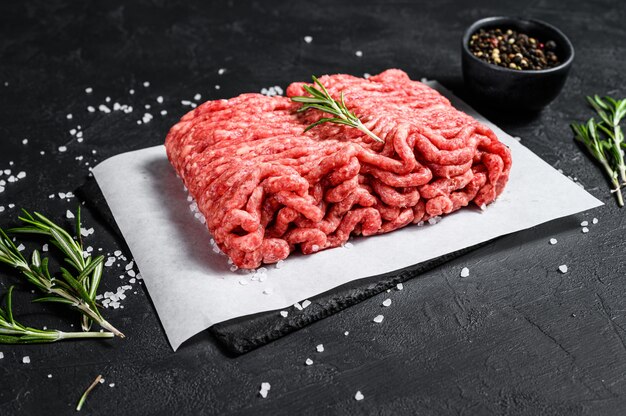 Raw minced pork. Black background. Top view. Space for text