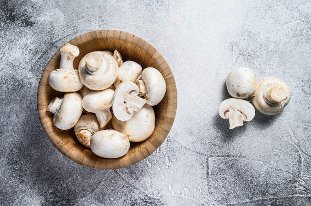 Raw mini mushroom champignon in a bamboo bowl.