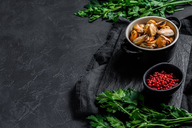 Raw mussel meat on a chopping Board with parsley.