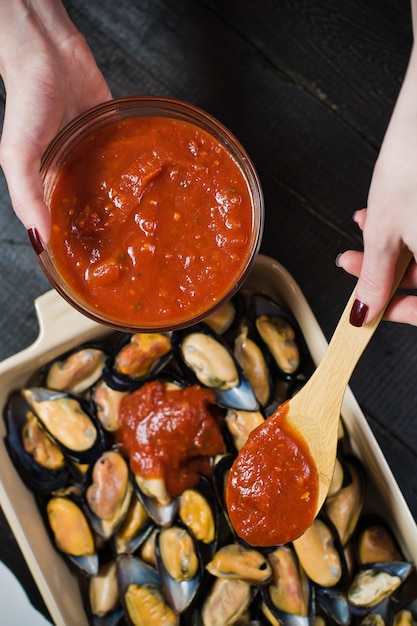 Raw mussels with tomato paste, cooking.