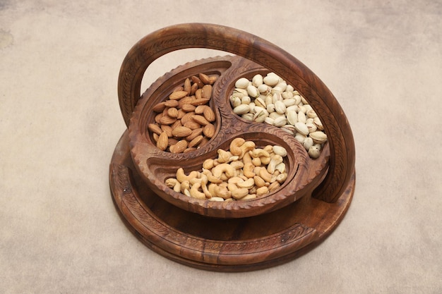 Raw Nuts in bowl on a plain background