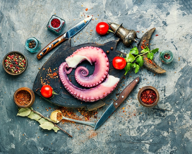 Raw octopus on kitchen board