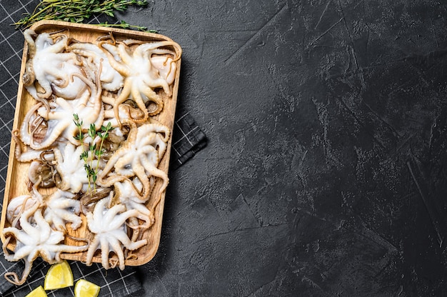 Raw octopus on a wooden tray