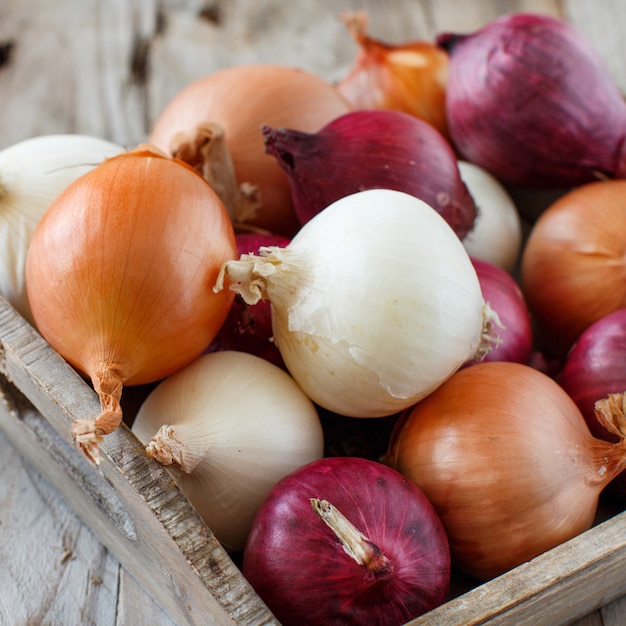 Raw onions in a basket on a wooden table