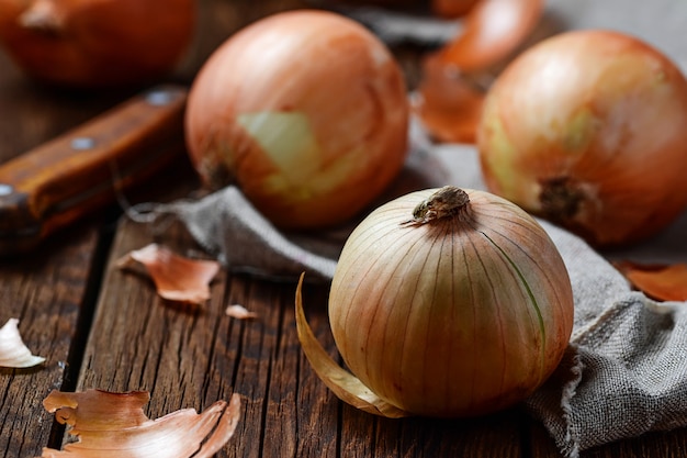 Raw onions on wooden background