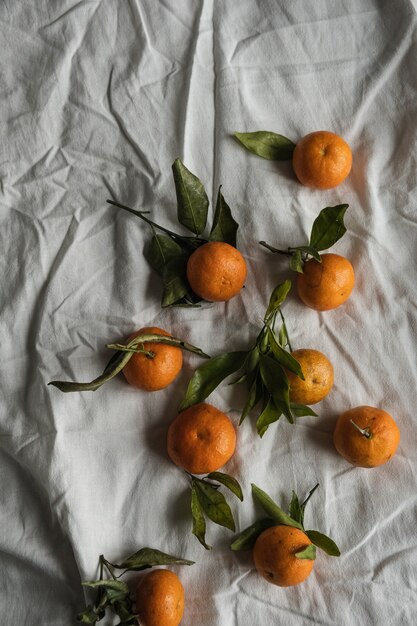 Raw oranges, tangerines on crumpled cloth