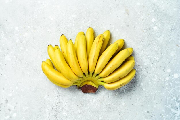 돌 배경에서 먹을 준비가 된 원시 유기농 바나나 무료 복사 공간 상위 뷰