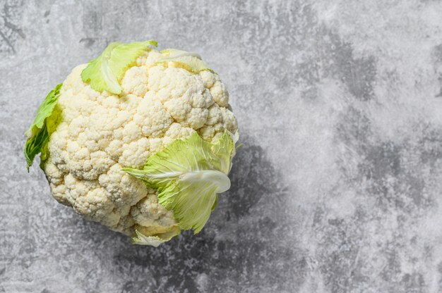 Raw organic cauliflower with leaves. Top view. Copy space