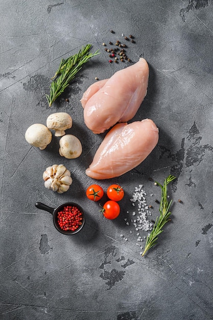 Raw organic chicken breast on a grey background. Food preparation, top view.