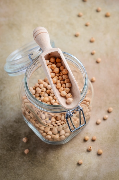 raw organic chickpeas in a glass jar, healthy vegan vegetarian food ingredient.