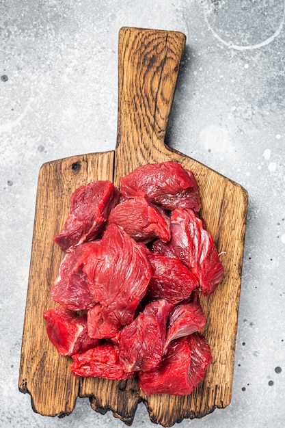 Raw organic diced lamb meat for cooking Goulash Gray background Top view