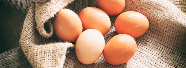 Raw organic farm eggs on burlap banner