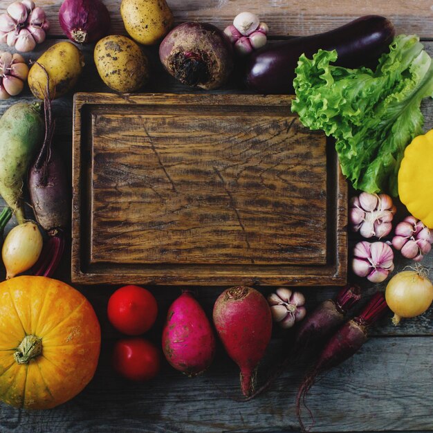Raw organic fresh vegetables and wooden board in rustic style