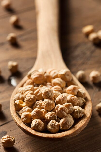 Photo raw organic garbanzo beans in a spoon