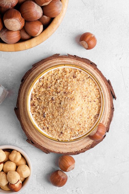 Raw Organic Ground Hazelnut Flour in a Bowl with whole nuts on grey stone background Alternative nut flour