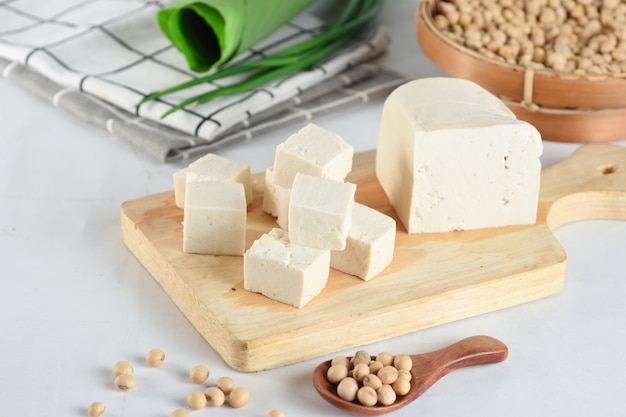 Raw organic vegetarian tofu cubes on wooden background