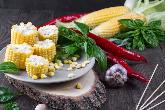 Raw Organic Yellow Corn on the Cob with hot chili pepper garlic and herbs. Mexican Corn