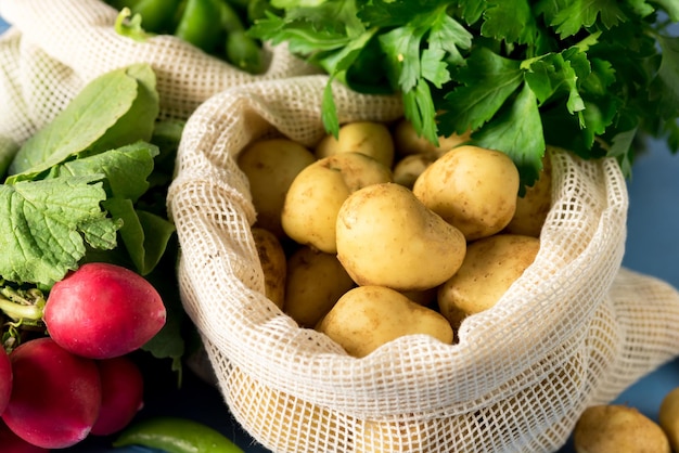 Raw organic young potato and raw bulk radishes herbs vegetable\
vegan healthy food