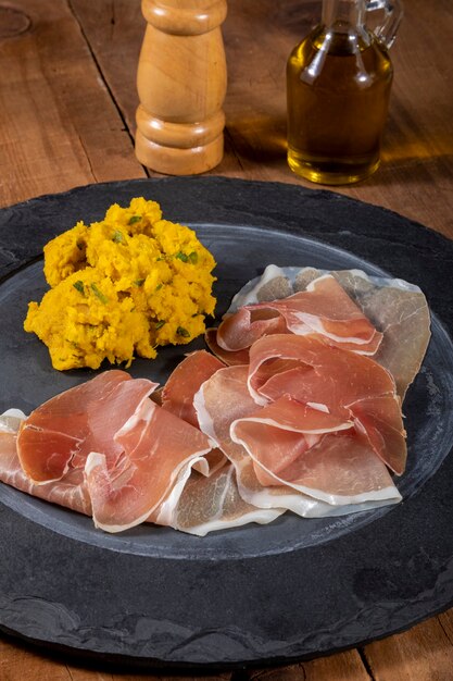 Raw parma ham and pumpkin mashed.