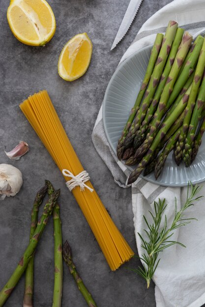 raw pasta and asparagus on grey