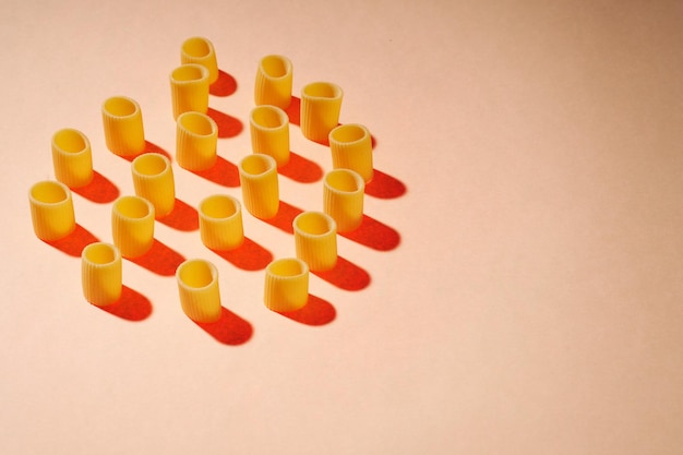 Raw pasta on a bright yellow background Food pattern