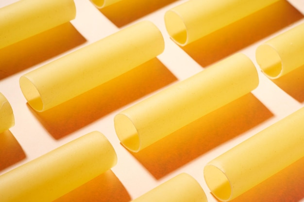 Raw pasta on a bright yellow background Food pattern