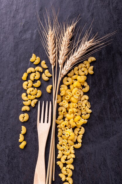 Foto pasta cruda e spighe di grano