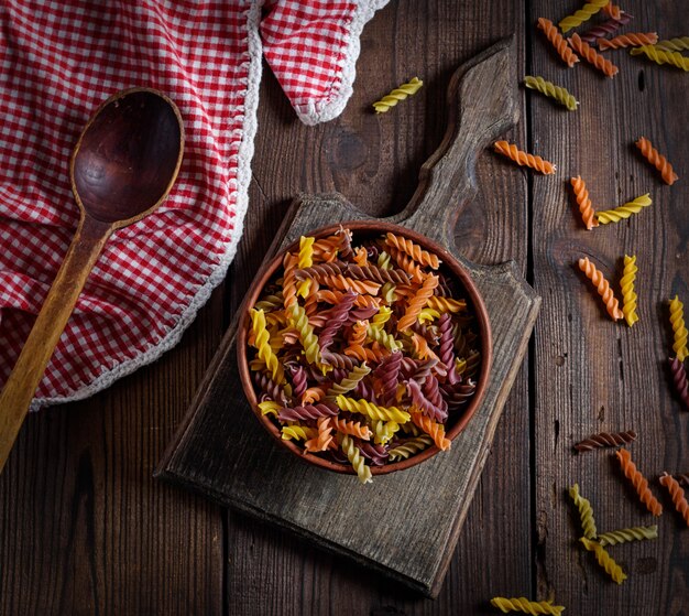 Raw pasta fusilli on a brown wooden table