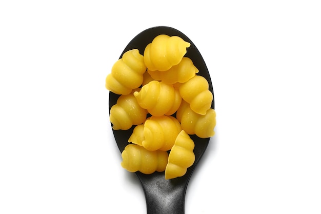 Raw pasta gnocchetti on wooden spoon on White background Top view of Italian cuisine ingredient