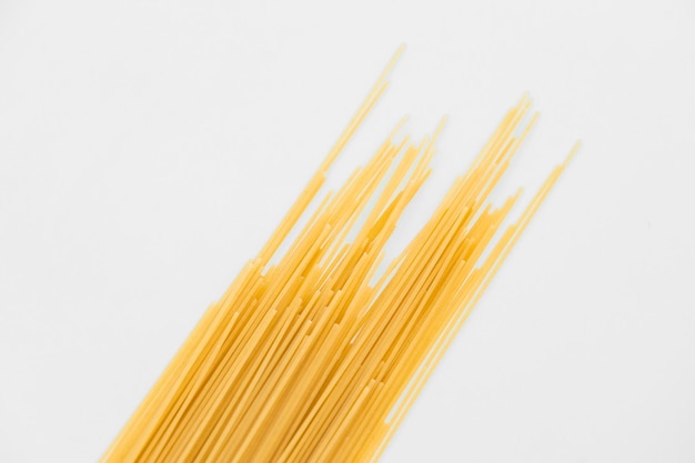 Foto spaghetti di pasta cruda isolati su sfondo bianco