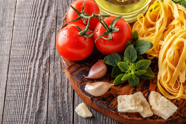 Raw pasta and tomatoes on a cutting board