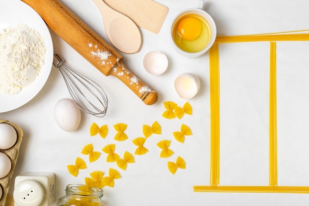 Raw pasta with ingredients on the white table Top view Different kinds of pasta Various types of pasta Italian cuisine Free space for text Pasta background Flour and eggs