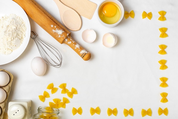 Raw pasta with ingredients on the white table Top view Different kinds of pasta Various types of pasta Italian cuisine Free space for text Pasta background Flour and eggs