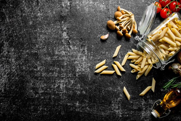 Raw pasta with oil tomatoes and mushrooms