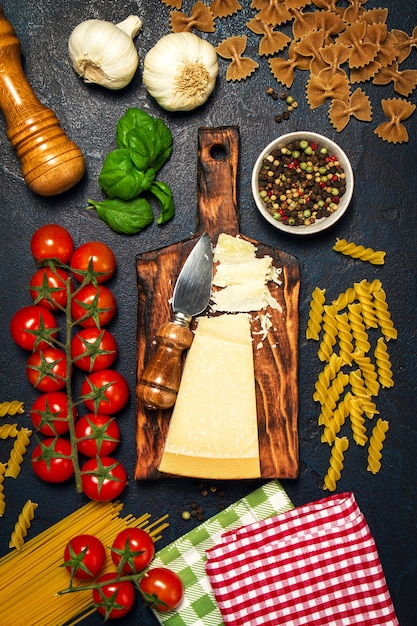 Foto pasta cruda con pomodoro e formaggio su un tavolo nero