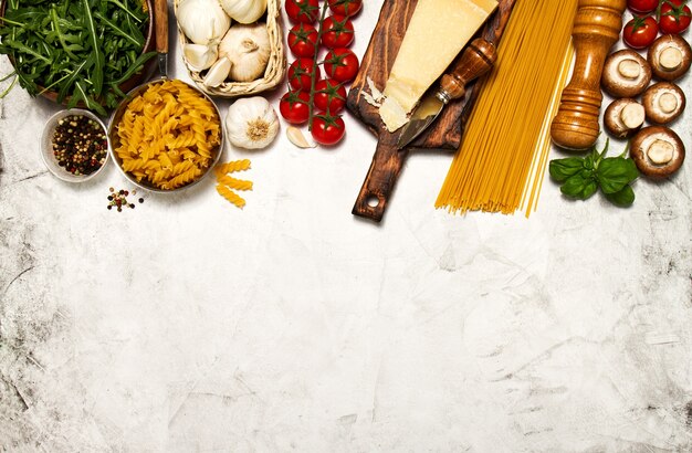 Foto pasta cruda con pomodoro e spezie su un tavolo bianco