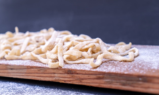 Raw pasta on wooden table