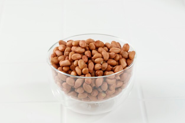 Raw Peanuts on Clear Bowl on White Table