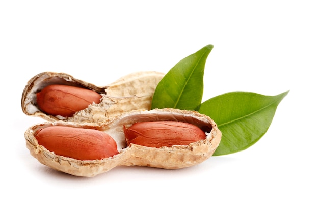 Raw peanuts on white background with green leaf. Healthy snack ona white background.Top view. close-up.