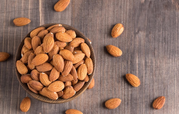 Raw peeled almonds in brown bowl