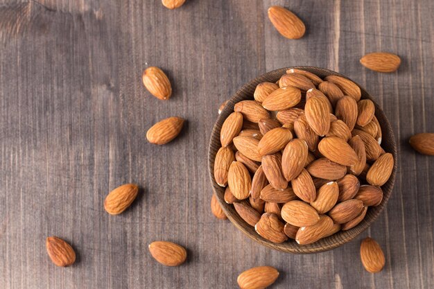 Raw peeled almonds in brown bowl