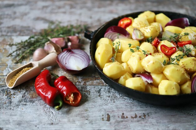 Raw peeled potatoes whole in a pan with spices, herbs and garlic before baking. Cooking Baked Potatoes. Selective Focus. 