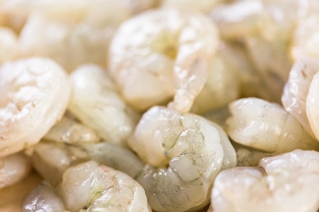 Raw peeled shrimp on a brown butcher paper.