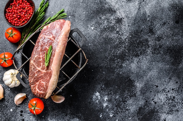 Raw picanha or  Top Sirloin Cap steak on a grill.  Top view. Copy space.