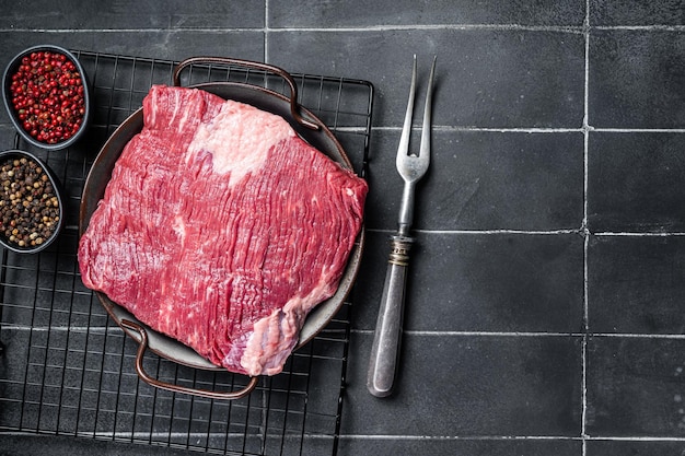 Raw piece of marble beef brisket meat with spices Black background Top view Copy space